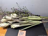 Group of cream and lavender artificial flower stems on table