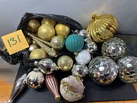 Group of assorted ornaments spread out plus bag holding more
