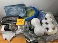 Overview of lot with Styrofoam balls, wallet, belt, pouches, fabric