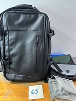 Front view of black backpack with file folders beside it
