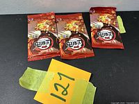 Front view of three sealed Demon Slayer trading card packs