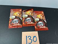front view of three sealed Demon Slayer trading card packs