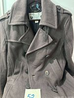 Front view of Diesel dark brown peacoat showing double-breasted design, lapels, buttons and epaulettes