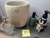 Group view of beige planter and three soap dispensers