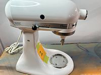 Left side view of white KitchenAid Classic stand mixer showing tilt-head and speed control