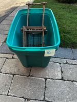 Teal plastic tote with twig wheelbarrow inside