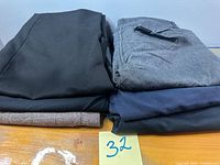 Stacked view of all four folded pants