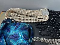 Overall lot showing faux pearl belt, black bead necklaces, sequined pouch, silver-tone bracelet