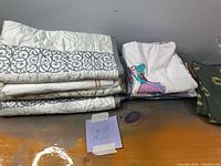 Stack of folded quilted shams, pillowcases and napkins