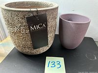 Beige MICA tagged planter and purple planter side by side