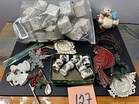 Overall lot showing bag of napkin rings, tin of mugs, metal cardinal wall hanging and assorted ornaments
