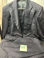 Full view of jacket, vest and folded trousers showing pinstripe pattern