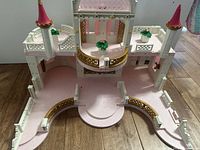 Front view of dollhouse showing full structure and planters