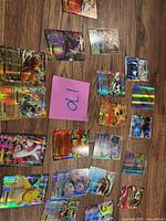 Spread of entire lot showing all holographic Pokémon cards on wooden surface