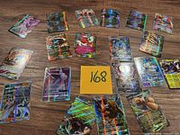 Circular arrangement of approximately 20 holographic Pokémon EX/GX cards on table with identifier card 168