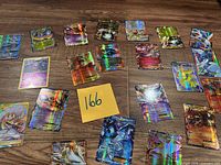 Spread of all holographic Pokémon cards on wooden surface with lot identifier visible