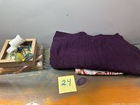 Lot overview showing folded purple curtain panel atop liner and hooks box