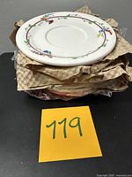 Stack of wrapped saucers showing floral rim of top piece