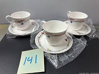 Three wrapped teacup and saucer sets displayed