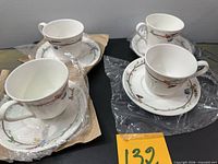 Four wrapped teacup and saucer sets displayed