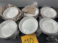 Six wrapped white ramekins with plum trim displayed on table