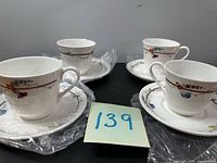 Four teacups with saucers wrapped in plastic