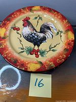 Front view of one charger showing rooster motif and border design