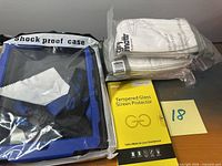 Overview of all three items: phone case package, screen protector box, stack of masks