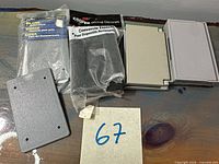 Four plastic blank outlet covers, two sealed packages (Carlon gray, Cooper black) plus two loose gray covers