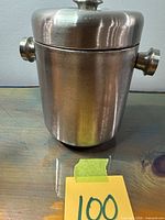 Full view of ice bucket with lid on, showing brushed finish and side knobs