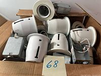 Box containing multiple white 5-inch recessed light trims with junction boxes