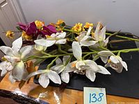 Group of white, yellow and purple silk flowers on green stems