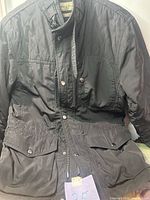 Front view of black Zara Man jacket showing quilting, pockets, zipper and snap closure