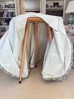 Underside view showing light wood tapered legs and white skirt lining