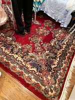 Full view of rug showing red field and pattern