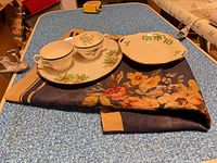 Group shot showing Lenox bowl, lusterware dish, two teacups, and needlepoint textile
