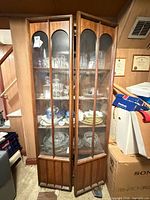 Front view showing double glass doors, shelves, wood finish