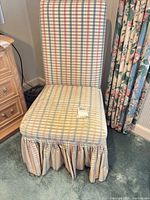 Front view of pastel plaid skirted upholstered chair