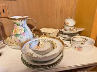 group shot of pitcher, basin, serving pieces, cups, plates, casserole