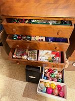 Dresser drawers and floor boxes containing numerous multicolor glass ornaments