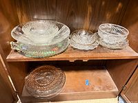 Upper cabinet shelf with Waterford bowl on platter, additional bowls and tray
