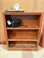 Front view of wooden bookcase showing three shelves