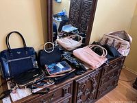 Overview of multiple handbags on dresser top