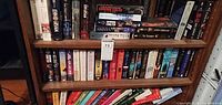 Bookshelves filled with assorted paperback and hardcover novels from noted authors