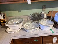 Group shot of all three casserole dishes with lids and meat tray