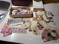 Overview of loose Canadian, U.S. and mixed world postage stamps, singles and blocks, and storage boxes