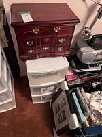 Overall lot showing jewelry box atop plastic drawer unit with frames nearby