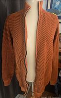 Front view of rust orange zipped cardigan on mannequin