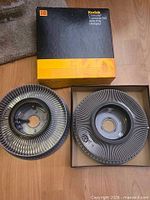 Both Kodak Carousel Transvue 140 slide trays side-by-side, one in box, one loose