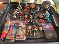 Overall view of all figures, PEZ dispensers and tin on black surface